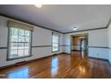 Hardwood floor living room, featuring large windows and green trim at 3129 Barwell Rd Rd, Raleigh, NC 27610