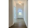 Bright hallway with wood-look flooring and white walls leads to a glass-paneled front door at 3284 Roundly Rd # 16, New Hill, NC 27562