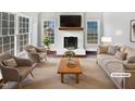 Virtually staged living room with a fireplace and large windows at 3321 Beech Bluff Ln, Raleigh, NC 27616