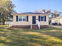 Charming yellow house with a neat lawn and white steps at 509 Mullins St, Rocky Mount, NC 27803