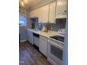 Bright kitchen with white cabinets, laminate flooring, and appliances at 6369 New Market Way, Raleigh, NC 27615