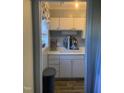 White kitchen with double sink, and laminate flooring at 6369 New Market Way, Raleigh, NC 27615