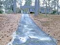 Charming single story home with mature trees, brick accents, and a long driveway at 7317 Bentley Wood Ln, Raleigh, NC 27616