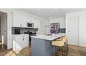 Modern kitchen with white cabinets, blue island, and stainless steel appliances at 937 Selby Ave, Durham, NC 27713