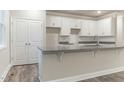 Modern kitchen with white cabinets, granite countertops, and an island at Lot 14H Poppy Mallow Ln, Oxford, NC 27565