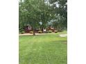 Quaint single-story home nestled among mature trees on a lush green lawn at 1018 Lakeview Dr, Cedar Grove, NC 27231