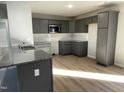 Modern kitchen with grey cabinets, granite countertops, and stainless steel appliances at 158 Pate Landing Dr, Selma, NC 27576