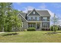 Beautiful home with a stone and siding exterior, a well-manicured lawn, and lush landscaping at 1625 Banks View Dr, Raleigh, NC 27603