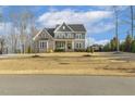 Inviting two-story home featuring stone and siding exterior with a covered front porch and a well manicured lawn at 1625 Banks View Dr, Raleigh, NC 27603