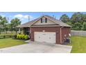 View of the brick home showing the attached garage and well maintained lawn at 2001 Bunnfield Dr, Zebulon, NC 27597