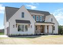 Beautiful two-story home featuring white siding, brick accents, dark trim, and a manicured lawn at 321 Bud Wall Rd, Youngsville, NC 27596