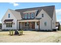 Beautiful two-story home with a charming front porch, brick accents, and lush landscaping at 321 Bud Wall Rd, Youngsville, NC 27596