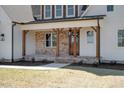 Inviting front porch features brick accents, wood columns, and a stylish entry with warm lighting at 321 Bud Wall Rd, Youngsville, NC 27596