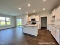 Open concept kitchen with an island and hardwood floors at 389 Springtooth Dr, Zebulon, NC 27597