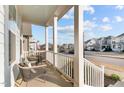 Relaxing front porch with white railings, two wicker chairs and a view of the street at 413 Holding Creek Dr, Wake Forest, NC 27587