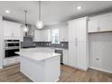 Modern kitchen featuring white cabinetry, stainless steel appliances, and a central island at 708 Georgias Landing Pkwy # 14, Raleigh, NC 27603