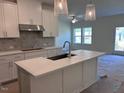 Modern kitchen featuring white cabinets, an island with sink, and pendant lighting at 7113 Hubner Pl # 20, Cary, NC 27519