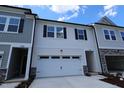 New construction townhouse featuring white siding, a two-car garage and decorative black shutters at 7117 Hubner Pl # 22, Cary, NC 27519