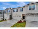 Townhome featuring a two-car garage, dark shutters, and manicured landscaping at 7117 Hubner Pl # 22, Cary, NC 27519