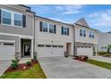 Townhome showcasing a two-car garage, dark shutters, manicured landscaping at 7117 Hubner Pl # 22, Cary, NC 27519