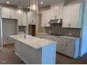 Modern kitchen with stainless steel appliances, white cabinets, and a center island at 7117 Hubner Pl # 22, Cary, NC 27519