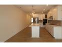 Open-concept kitchen with island, stainless steel appliances and bright pendant lighting at 7117 Hubner Pl # 22, Cary, NC 27519