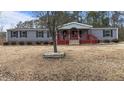Gray siding ranch home with a covered porch and landscaping at 7228 Pecan Tree St, Willow Springs, NC 27592