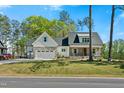 Inviting two-story home with a stone-accented facade, two-car garage, and a lush green lawn at 810 Maggie Way, Wendell, NC 27591