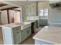 The kitchen is equipped with grey cabinets, a marble countertop, and a white farmhouse sink at 810 Maggie Way, Wendell, NC 27591