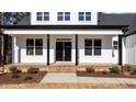 Inviting front porch with black columns and door, brick-lined steps, and well-manicured landscaping at 85 Arbor Dr, Youngsville, NC 27596