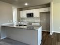Modern kitchen featuring white cabinets, granite countertops, and stainless steel appliances at 93 Faucette Dr, Selma, NC 27576