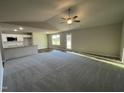 Spacious living room with high ceilings, ceiling fan, and neutral-toned carpet at 93 Faucette Dr, Selma, NC 27576