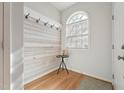 Welcoming entryway with wood-look accent wall, coat hooks, and natural light from arched window at 2031 Rivergate Rd # 105, Raleigh, NC 27614