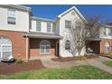 Beautiful exterior of townhome with brick facade, arched windows, and manicured lawn at 2031 Rivergate Rd # 105, Raleigh, NC 27614