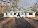 White Ranch style home with black windows, landscaped yard, and covered carport at 213 Drew St, Louisburg, NC 27549