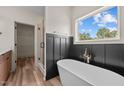 Stylish bathroom with a freestanding tub, elegant fixtures, wainscoting, and a glass-enclosed shower at 250 Ellington Rd, Graham, NC 27253