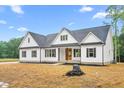 Inviting white home featuring a welcoming front porch, dark shutters, and manicured landscaping at 250 Ellington Rd, Graham, NC 27253