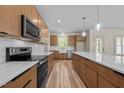 Bright kitchen with wooden cabinetry, quartz countertops, stainless appliances and hardwood floors at 250 Ellington Rd, Graham, NC 27253
