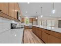 Bright kitchen featuring wooden cabinetry, quartz countertops, stainless appliances, and hardwood floors at 250 Ellington Rd, Graham, NC 27253