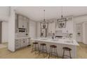 Bright kitchen features a central island with seating, stainless appliances and modern pendant lighting at 2801 Mount View Church Rd, Moncure, NC 27559