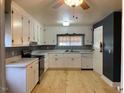 Bright kitchen with white cabinets, stainless steel appliances, and light wood floors at 3077 Christian Light Road Rd, Fuquay Varina, NC 27526