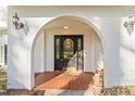 Elegant arched entryway with a black door and sidelights at 3872 Hope Valley Rd, Durham, NC 27707