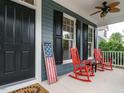 Inviting front porch with red rocking chairs and American flag at 401 Streamwood Dr, Holly Springs, NC 27540