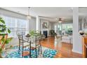 Open dining area with hardwood floors, glass top table, and access to living area at 701 Brickstone Dr, Apex, NC 27502