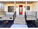 Inviting front porch with a vibrant red door, black iron railings, and steps leading up to the entrance at 727 Cook Rd, Durham, NC 27713