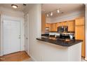 Kitchen with breakfast bar featuring stainless appliances, granite countertops, and wood cabinets at 1300 Durlain Dr # 108, Raleigh, NC 27614