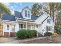 Traditional two-story home featuring a welcoming front porch, dormer window, and manicured landscaping at 3212 Potthast Ct, Raleigh, NC 27616