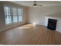 Bright living room featuring a modern fireplace, wood floors, and an abundance of natural light from multiple windows at 3212 Potthast Ct, Raleigh, NC 27616