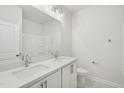 Modern bathroom featuring double sink vanity with a large mirror and updated lighting at 4804 Cypress Tree Ln, Raleigh, NC 27612