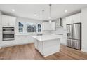 New kitchen with large island, stainless steel appliances, white cabinetry and natural light at 4804 Cypress Tree Ln, Raleigh, NC 27612